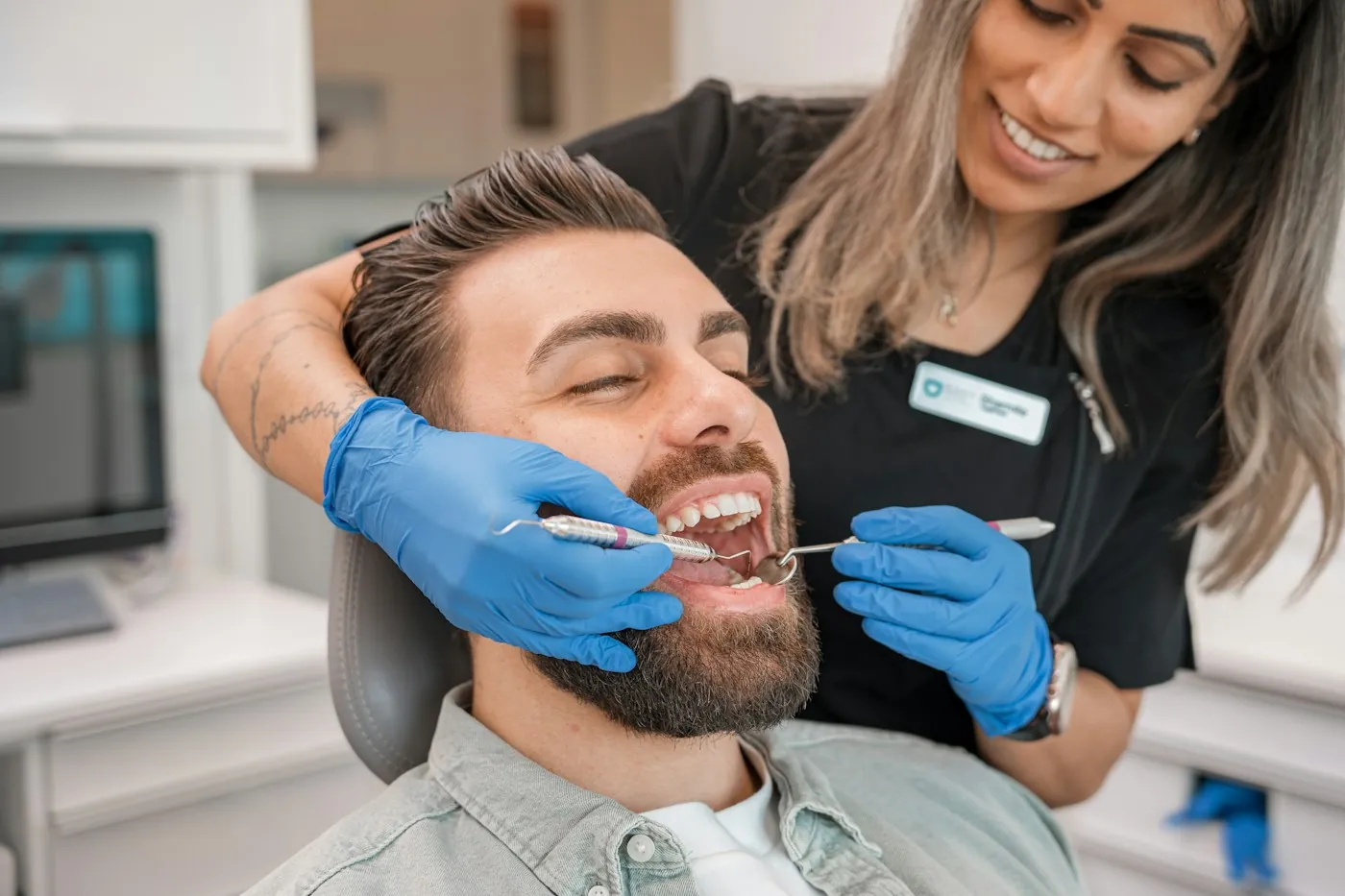 Dentista atendendo paciente sorridente
